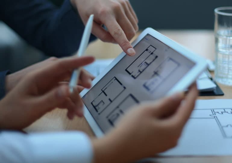 Two people discussing an apartment scheme on a tablet