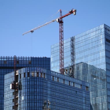 A tower crane building glass wall skyscrapers
